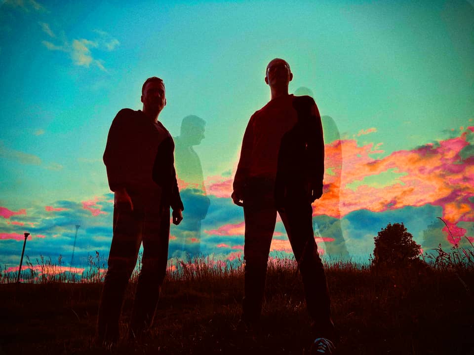 Massimo Cambiano standing in a field under a sunset sky